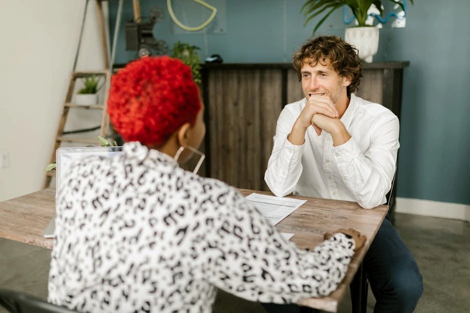 Dizüstü bilgisayarıyla gülümseyen genç bir profesyonel